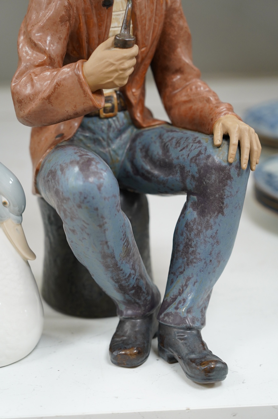 A large Nao seated figure of a fisherman and a similar swan, largest 41cm high. Condition - good